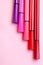 Five markers or pens of pink, purple, pink color lie like steps on a pink background, isolated mock up