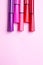 Five markers or pens of pink, purple, pink color lie on a pink background, isolated mock up