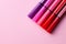 Five markers or pens of pink, purple, pink color lie on a pink background, isolated mock up