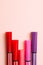 Five markers or pens of pink, purple, pink color lie on a pink background, isolated mock up