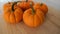 Five mini pumpkins on a wooden table