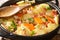 Five-minute potatoes with bacon, onions and carrots close-up in a frying pan. horizontal