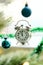 Five minutes to noon: a clock on a window cell through  Christmas tree