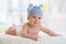 Five months baby boy weared in funny hat lying down on a blanket
