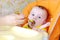 Five-months baby is fed by puree from a spoon