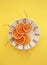 Five orange slices on the plate on yellow background.