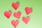 Five paper hearts surrounding one '' broken, lonely, down '' Green background