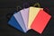 Five paper multi-colored shopping bags on black wooden background. Top view