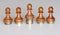 Five pawns of chess pieces on columns of coins symbolizing the exclusion from equal income