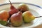 Five pears in a plate on a table