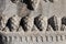 Five pine cones engraved in stone as decoration on the facade of