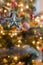 Five-pointed star dangles in front of colorful Christmas Tree