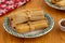 Five Pork Tamales on a Green and White plate on a rustic table
