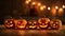 five pumpkins lined up in a row with candles