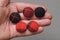 Five red black buttons lying on the palm on the hand