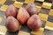 Five Red Pears on a Wooden Chessboard