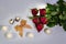 Five red roses with four raffaello and two chocolade sweets and a golden bow on a white background