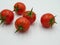 Five ripe tomatoes on a white background