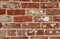Five rows of weathered red bricks in wall