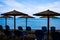 Five Rustic Palapa Umbrellas located at the shoreline of the mediterranean sea with Folding Blue Chairs over the Sand, Beautiful V