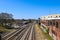 Five sets of railroad tracks near a red brick building with graffiti with railroad traffic signals