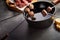 Five skewers hanging over fondue pot