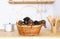 Five small puppies of a dachshund are in the big straw basket standing on a kitchen table