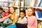 Five smiling children sitting in a row on floor