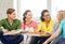 Five smiling teenagers eating pizza at home