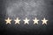 Five stars on a dark background. The concept of rating and evaluation. The rating of the hotel, restaurant, mobile application.