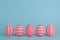 Five striped Easter pink eggs in a row. Blue background. Copy space.