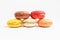 Five sweet French macarons with different aromas, isolated on white, flavours of strawberries, lemon, caramel, vanilla, orange and