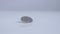 Five swiss franc coin rolling on white surface, slow motion