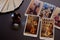 Five tarot cards, crystal ball, and Tarot deck on black table.