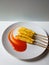 five telor gulung or egg rolls or fried egg crispy with stick topped with sauce on a white plate with  white background .