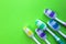 Five toothbrushes lie on a green background