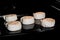 Five uncooked cinnamon buns on tray in electric oven, black background