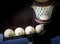 Five white billiards balls scored in the hole, the light in the hole, the background close-up