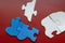 Five white and blue puzzle pieces on a burgundy background