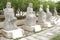 Five white marble Buddha statues in a garden, China