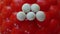 Five white snake eggs on a geometric red background.