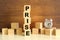 Five wooden cubes stacked vertically on a brown background make up the word PRISE.