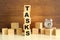 Five wooden cubes stacked vertically on a brown background make up the word TASKS