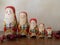 Five Wooden Santa Nesting Dolls with Berries Standing in a Row