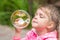 Five-year girl inflates large circular bubble