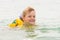 Five-year girl joyfully swimming in sea in a swimming vest