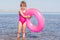 Five-year girl in pink bathing suit standing with swimming laps in the river