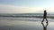 Five-year girl walks along beach in boots autumn day