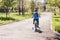 Five year old boy in a blue vest riding a bike in a spring Park