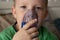 five-year-old boy breathes a black nebulizer. close up